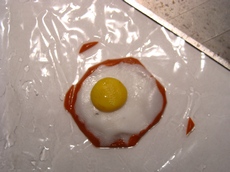 Обрезаем излишки коричневой пластики по краям яичницы